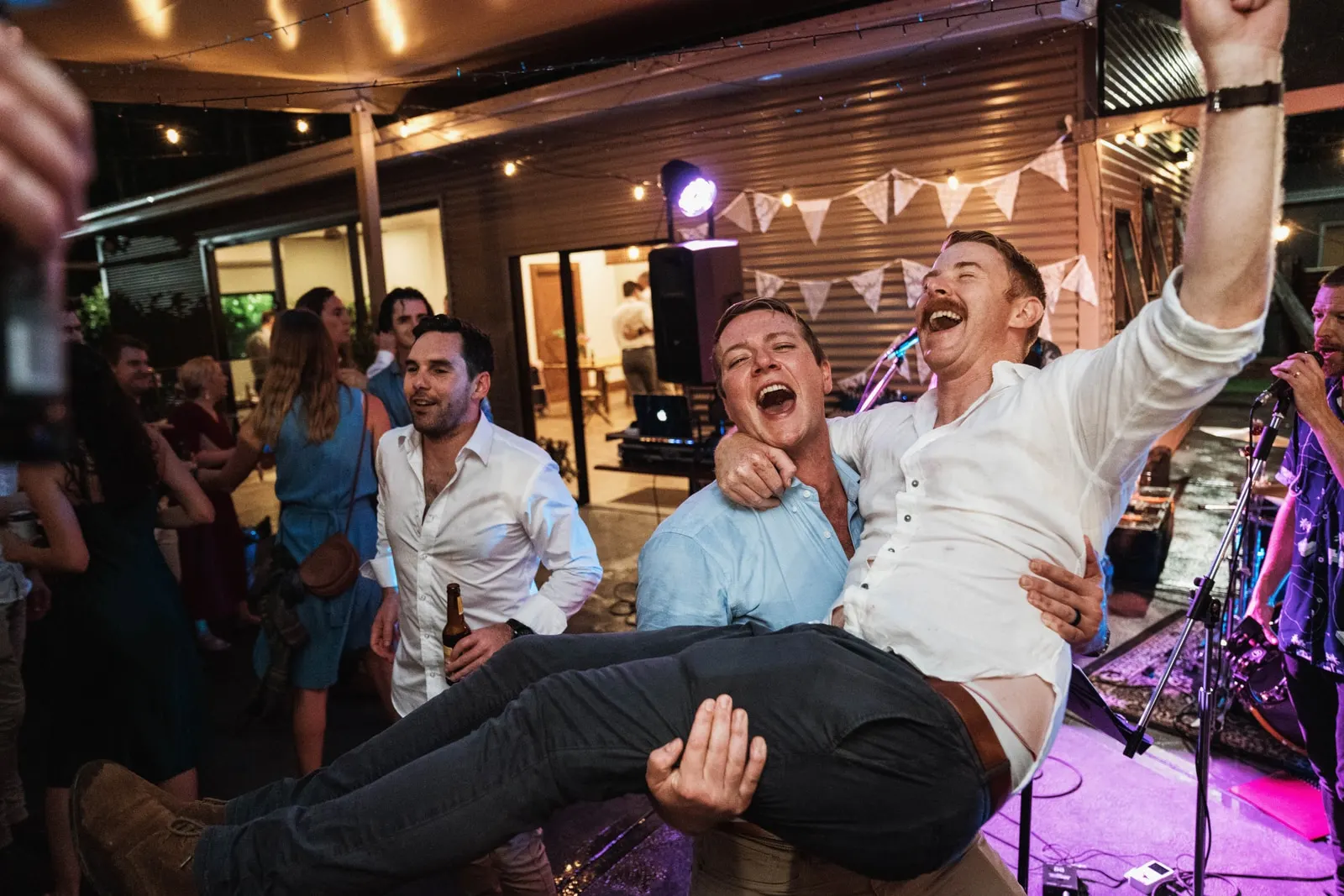 Guests celebrating outdoors at night with a live band playing nearby